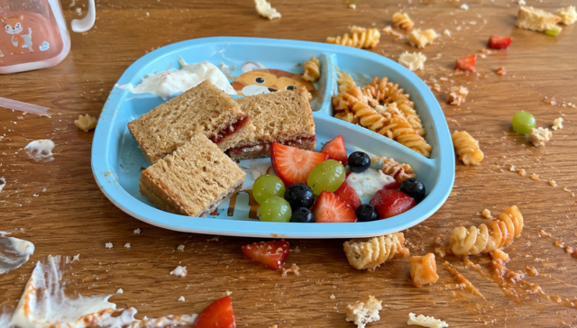 Partially eaten children's meal with food scattered across a table, illustrating picky eating in children and common mealtime challenges faced by families.