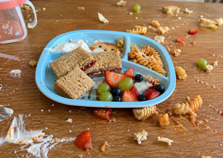 Partially eaten children's meal with food scattered across a table, illustrating picky eating in children and common mealtime challenges faced by families.